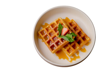 Two waffles with caramel, strawberry, and mint in a white plate, a cropped PNG object.