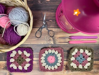 Basket with clews and granny square crocheted sample and candle light cozy photo hobby handmade craft crochet materials