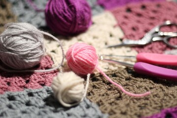 Granny square crocheted blanket with different colors motives, retro vintage craft handmade handiwork crocheting, beautiful plied photo cozy winter or autumn background wool thing yarn lovely warm