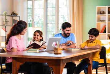 Parents teaching kids at home using laptop and books during study session in living room