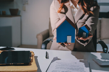 Female Real Estate Broker presenting and advised to .model home and building project detail in the...