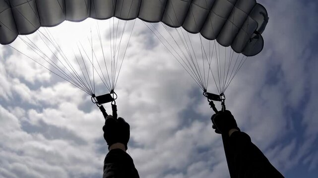 Hands Holding Parachute Risers Above