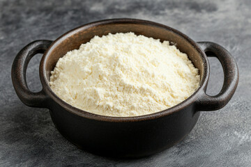 Scooping protein powder from a container into a shaker bottle for nutritional enhancement during workout preparation