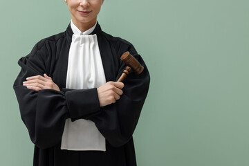Judge with mallet on light green background, closeup. Space for text