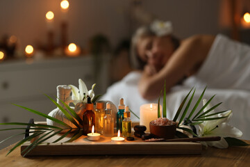 Senior woman relaxing on massage couch indoors, focus on different spa products
