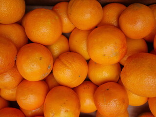 A bunch of oranges are piled up in a box
