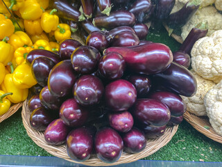 Fresh eggplants lie in a pile at the store on the counter for sale