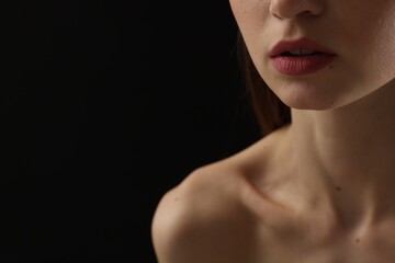 Woman with perfect skin on black background, closeup. Space for text