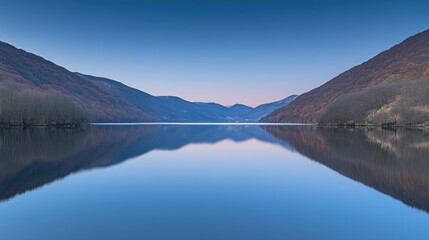 Naklejka premium Serene lake mirroring autumnal mountains under a twilight sky