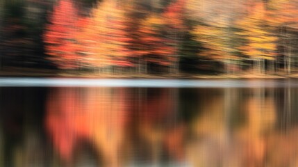 Fototapeta premium Abstract autumnal landscape with blurred trees reflected in still water.
