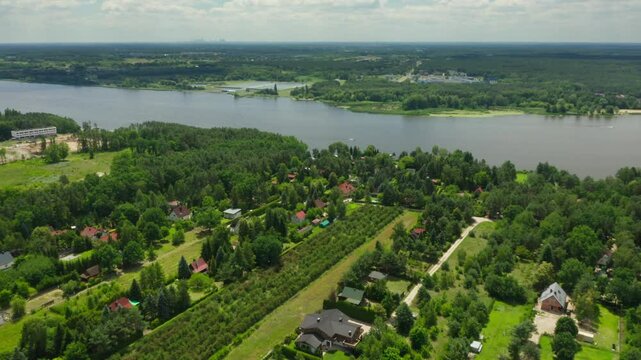 Overhead view of Jachranka village, part of Serock, by Poland's Narew River. Summer cottages are nestled in verdant landscapes with gardens, showing an idyllic retreat close to Warsaw.