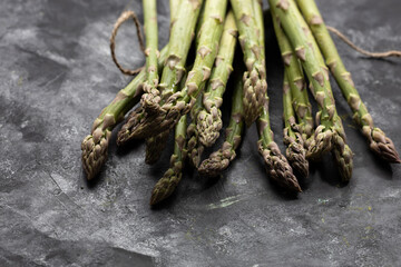 Bunch of fresh green asparagus on black surface healthy food