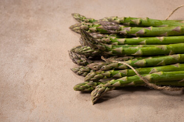 Bunch of  green asparagus on stone surface copy space