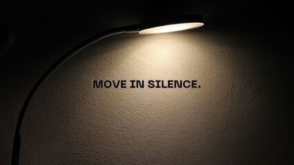 move in silence motivational quote spotlight illuminated wall text