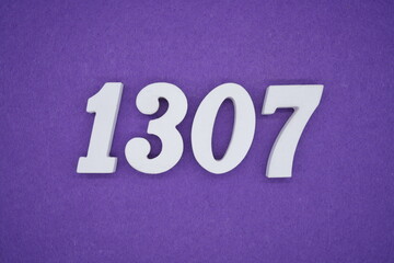 The numbers are made of white painted wood placed on a purple paper background.
