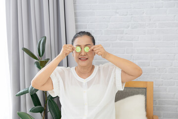 senior, woman, skincare, beauty, cucumber: Asian mature senior woman smiles holding cucumber slice...
