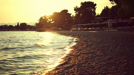 Golden hour sunset over a tranquil lake beach.