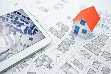 Buildings Permit concept with imaginary cadastral on digital tablet - building activity and construction industry concept with General Urban Plan and home model