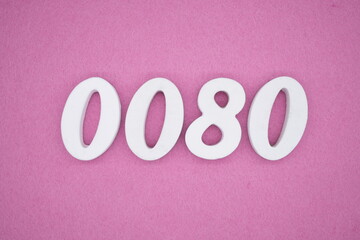 The numbers are made of white painted wood, placed on a pink paper background.
