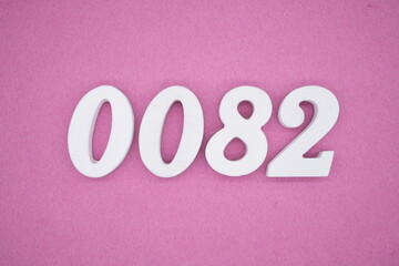The numbers are made of white painted wood, placed on a pink paper background.