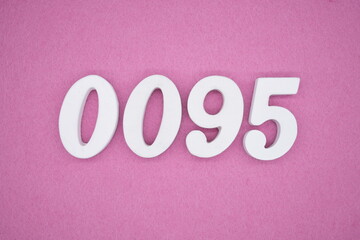 The numbers are made of white painted wood, placed on a pink paper background.