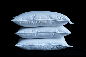 Three pristine white pillows stacked neatly against a black backdrop, showcasing comfort and elegance