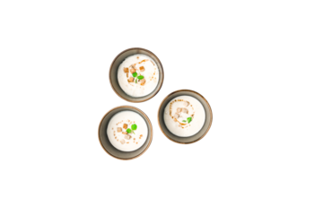 Top View of Three Bowls of Indian Dahi Vada Garnished with Spices and Herbs on PNG Background