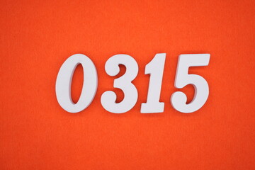 The numbers are made of white painted wood placed on an orange paper background.
