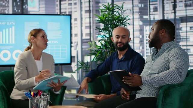 Corporate leadership team in a business meeting use data driven analysis and strategic thinking to identify insights and guide executive decisions across a global company. Camera B.