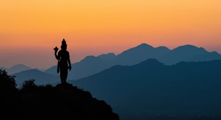 Obraz premium Serene Sunset Silhouette: A Statue's Mountaintop Vigil
