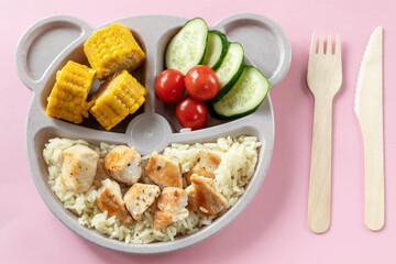 Baby food on a plate. Wooden fork and knife. Lunch or dinner option for a child.