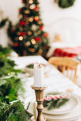 Festive Christmas dining setup with candlelight and holiday decorations in a cozy room