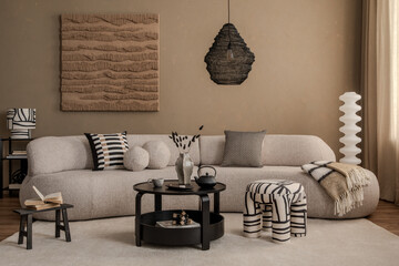 Contemporary neutral living room with a soft-textured sofa, black round coffee table, abstract wall art, and decorative pillows. Calm earthy color scheme.
