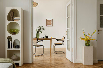 Minimalist dining room with mid-century modern chairs, wooden table and a green vase with yellow spring flowers. Neutral tones and clean styling emphasize natural textures.