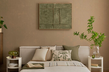 A serene bedroom with beige walls and a green-toned abstract mock up poster above a neatly made bed with neutral and botanical-themed cushions. Home decor.
