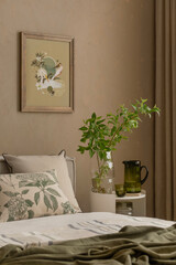Close-up of a cozy bed corner with green glassware, leafy branches in a vase, and a botanical cushion under a nature-inspired mock up poster. Home decor.