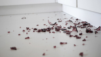 Close up of shattered violet glass on the kitchen floor