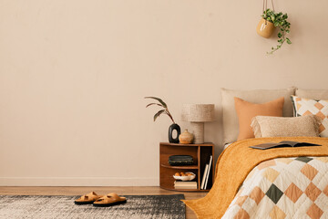 Minimalist composition of bedroom interior with copy space, bed, orange bedding, wooden bedside table, patterned rug, plants, stylish lamp, slippers and personal accessories. Home decor. Template.