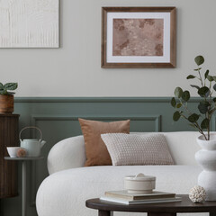 Spring composition of cozy living room interior with mock up poster frame, boucle sofa, wooden coffee table, pillows, white slippers, stylish sculpture and personal accessories. Home decor. Template.