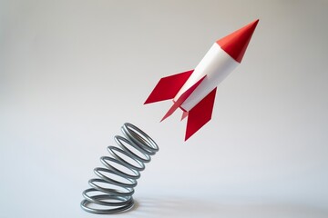 paper rocket fly up from spring. Grow and leverage
