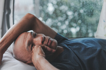 Close-up of a sad asian senior man with lonely alone on a rainy day and thinking about something, Elderly health concept, depression and mental health, World Senior Citizen's Day.