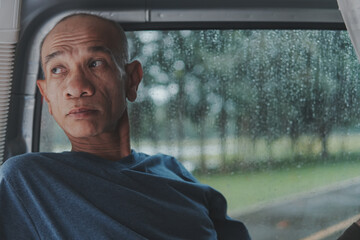 Close-up of a sad asian senior man with lonely alone on a rainy day and thinking about something, Elderly health concept, depression and mental health, World Senior Citizen's Day.