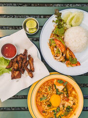 Variety of colorful Thai dishes on wooden table