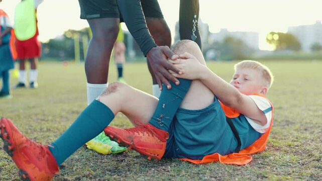 Soccer field, coach and kid with knee pain for injury, bone dislocation and muscle tension in sports. Pitch, hands and football player with ache for patellar tendinitis, accident or child with help