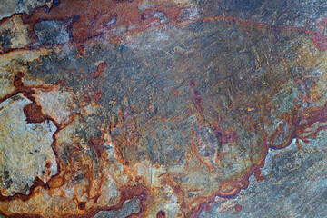 Stone surface with rusty orange and brown texture.