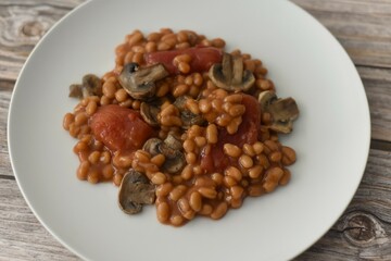 Baked beans in a rich tomato sauce with canned tomatoes and fried mushrooms.