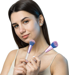 Close-up of a young girl in a light top on a white background making a facial make-up. A pretty...
