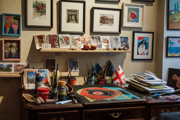 Eclectic artist studio in Tbilisi old town. Art-filled interior with canvases, brushes, handmade signs, posters, framed paintings and creative chaos