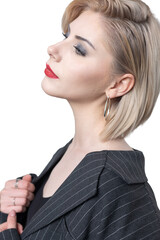 Portrait of a seductive, stylish business lady in the studio. Blonde girl in a suit and top.