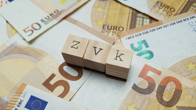 ZVK acronym made of wooden letter cubes on pile of Euro banknotes. Zusatzversorgungskasse (Supplementary Pension Fund)
